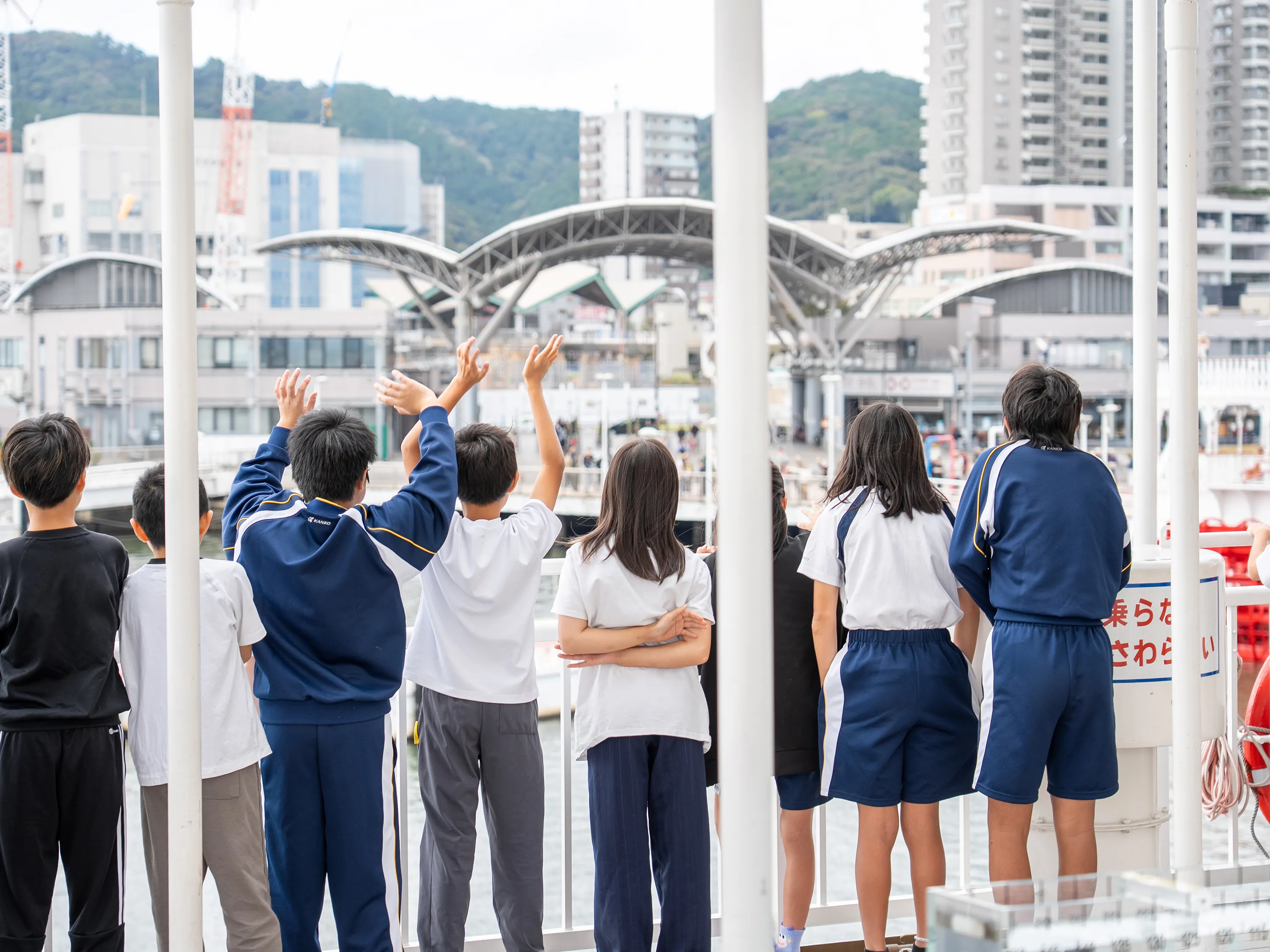 出航で手を振る子どもたち